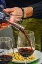 Hand of a man holding a decanter and pouring red wine in a glass Royalty Free Stock Photo