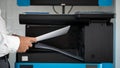 The hand of the man holding the document and the printer on the back for office Royalty Free Stock Photo