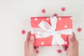Hand of man holding gift giving on wooden table in Christmas day or holiday, present box for anniversary. Royalty Free Stock Photo
