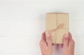 Hand of man holding gift giving on wooden table in Christmas day or holiday, present box for anniversary. Royalty Free Stock Photo