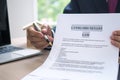 The hand of a man holding a house purchase contract with a pen showing up to customers. House salesman is showing Landlord-Tenant