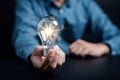 Hand man holding illuminated lightbulb, idea, innovation and inspiration with glowing virtual brain, smart intelligent creativity Royalty Free Stock Photo