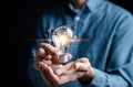 Hand man holding illuminated lightbulb, idea, innovation and inspiration with glowing virtual brain, smart intelligent creativity Royalty Free Stock Photo