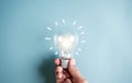 Hand man holding illuminated lightbulb, idea, innovation and inspiration with glowing virtual brain, smart intelligent creativity Royalty Free Stock Photo