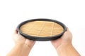 Hand of a man holding a Japanese spiral wooden tray with bamboo Royalty Free Stock Photo