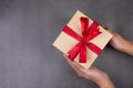 Hand of man holding kraft gift box on cement floor in Christmas day or holiday. Royalty Free Stock Photo