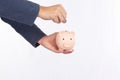 Hand of man holding pink piggy bank and put coin for saving isolated on white background, saving concept Royalty Free Stock Photo