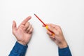 The hand of a man holds a screwdriver with a red handle on a white background, the hands of a master in a shirt close-up Royalty Free Stock Photo