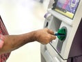 Hand of man insert card into ATM machine for withdraw money with blurry background. Royalty Free Stock Photo