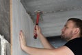Man insert plastic cleat in to the hold of concrete wall and hammer to hit it