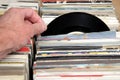 Hand of a man looking at vinyl 7& x22; single 45 rpm records for sale at a retro record fair Royalty Free Stock Photo