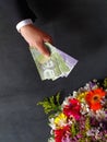 hand of a man paying with chilean money for a bouquet of flowers