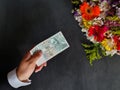 hand of a man paying with Czech money for a bouquet of flowers