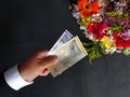 hand of a man paying with danish money for a bouquet of flowers