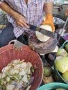 Hand man peeling coconut with knife