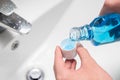 Hand of man Pouring Bottle Of Mouthwash Into Cap Royalty Free Stock Photo