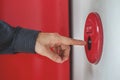 Hand of man is press fire alarm switch on the white wall as background for emergency case at the building. Royalty Free Stock Photo