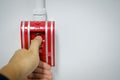 Hand of man pulling fire alarm switch on the white wall as background for emergency case at the new factory building. Royalty Free Stock Photo