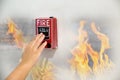 Hand of man pulling fire alarm switch on the white wall as background for emergency case at the new factory building. Royalty Free Stock Photo