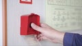 The hand of man is pushing fire alarm on the wall. Clip. Hand of man pushing fire alarm switch on the white wall as Royalty Free Stock Photo