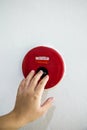 The hand of man is pushing fire alarm on the wall. Royalty Free Stock Photo