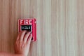 The hand of man is pushing fire alarm on the wall. Hand of man pushing fire alarm switch on the white wall as background for emerg Royalty Free Stock Photo