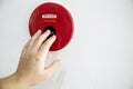 The hand of man is pushing fire alarm on the wall. Royalty Free Stock Photo