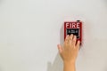 The hand of man is pushing fire alarm on the wall. Royalty Free Stock Photo