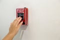 The hand of man is pushing fire alarm on the wall. Royalty Free Stock Photo