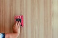 The hand of man is pushing fire alarm on the wall. Hand of man pushing fire alarm switch on the white wall as background for emerg Royalty Free Stock Photo