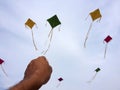 Hand of a man raises a kite in a sky