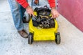 Hand of man repairing old grass cutter with tools on cement floor. Repairing lawn mower engine Royalty Free Stock Photo