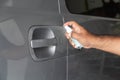 Hand of is man spraying alcohol, disinfectant spray on handle of car door,safety Royalty Free Stock Photo