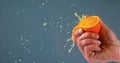 Hand of Man Squeezing Orange against Black Background Royalty Free Stock Photo