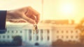 the hand of a man in a suit holds a key against the backdrop of the White House Royalty Free Stock Photo