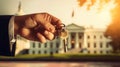 the hand of a man in a suit holds a key against the backdrop of the White House Royalty Free Stock Photo