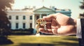 the hand of a man in a suit holds a key against the backdrop of the White House Royalty Free Stock Photo