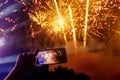 Hand of man taking the photo to fireworks with the new smartphone