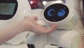 Hand of man touches the robot. Robot is happy with the touch of a human. Technology concept