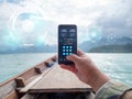 Hand of man using mobile smart phone against scenic landscape of boat view in the big river and reservoir dam with mountain and Royalty Free Stock Photo