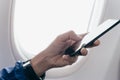 Hand of man using smart phone on airplane Royalty Free Stock Photo