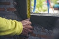 Ã Â¹â¡Hand of man using tape measure window with brick wall background. Construction Workers work at construction site.  Worker work Royalty Free Stock Photo