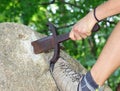 hand of the man who forcibly tries to extract the sword Excalibu Royalty Free Stock Photo