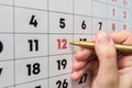 Hand marker indicates the 12th number in the wall calendar