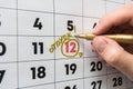 Hand marker on the wall calendar marks the date of the holiday