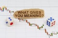 On the trading charts, there are dice and pieces of paper with the inscription - WHAT GIVES YOU MEANING