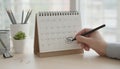 Hand marking tax deadline date on desk calendar Royalty Free Stock Photo
