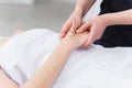 Hand massage. Physiotherapist pressing specific spots on female palm. Professional health and wellness acupressure