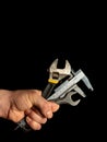 The hand of the master holds a set of tools for repairing plumbing