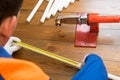 Hand of the master measuring tape measure the pipe before installing the plumbing, next tool for spikes, on wooden background Royalty Free Stock Photo